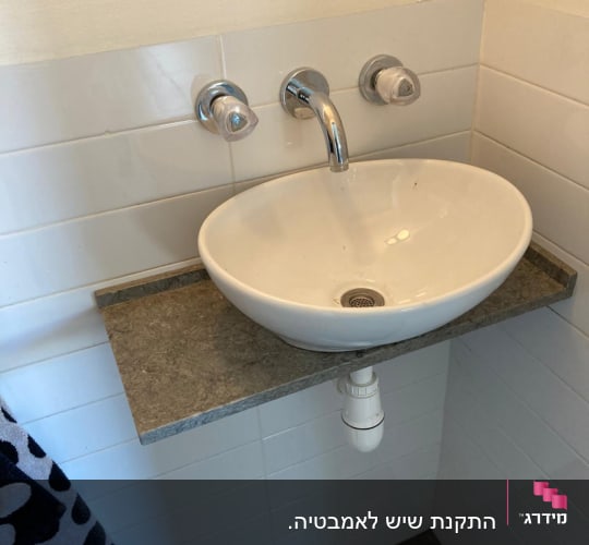 משטח שיש רחף בחדר אמבטיה עם כיור מונח לבן
